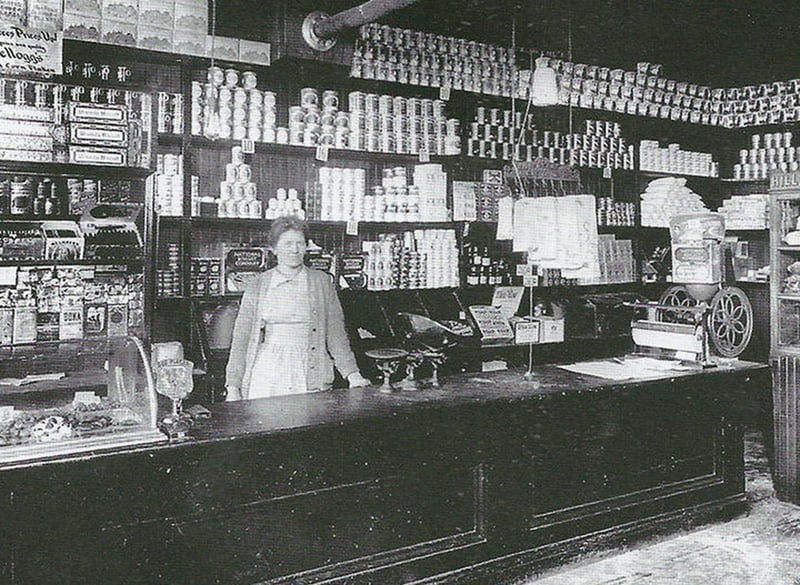 woman standing behind counter of old mom and pop store