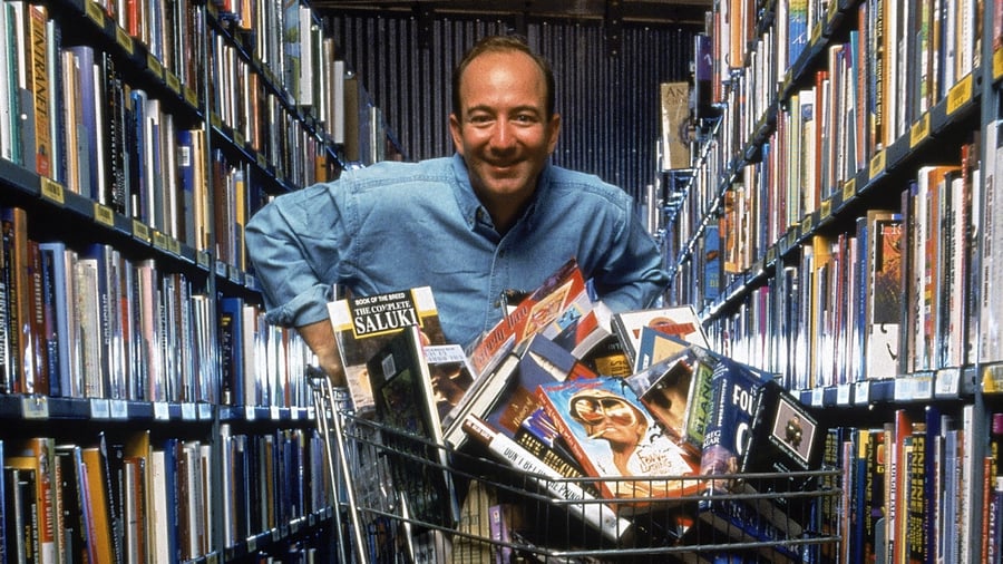 Jeff Bezos holding a shopping cart full of books