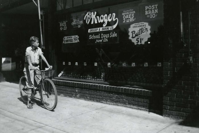 boy on bicycle outside of Kroger store window